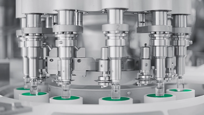 Sealing machine securing caps on vials
