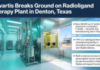 Novartis Expands Radioligand Therapy Manufacturing in US Novartis breaks ground on a radioligand therapy plant in Denton, Texas; construction site with blue-lit lab rooms in the background.