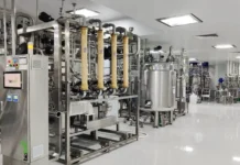 Shilpa Biologicals Launches PartnerPower Platform for CDMOs Industrial bioprocessing facility with stainless steel pipes, tanks, and control panels in a clean, bright room