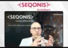 Eschbach Unveils a New Era of Intelligent Operations Presenter in a white blazer speaks on a large screen displaying SEQONIS branding and 'Intelligent Operations Platform' text.