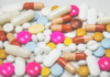 Digital Twins in Pharmaceutical Manufacturing: Why Simulation Alone Is No Longer Enough Assorted colorful pills and capsules scattered on a white background.